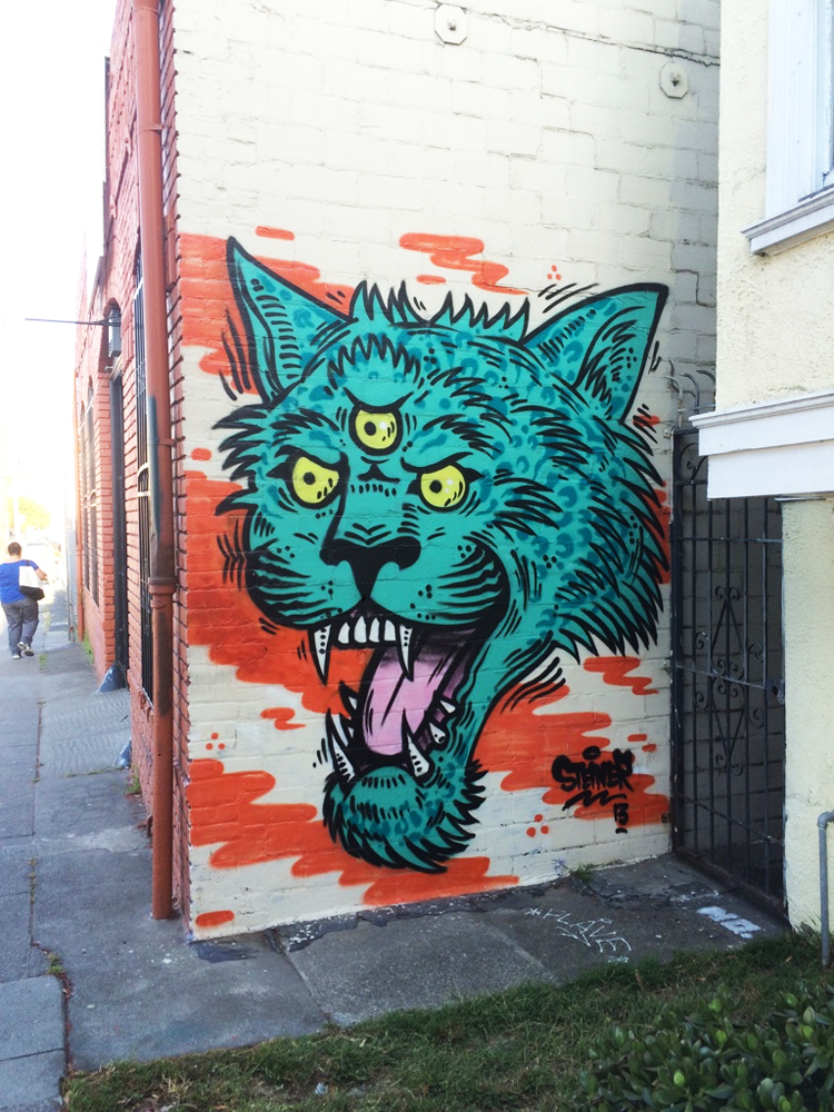 Turquoise three-eyed cat graffiti in Oakland