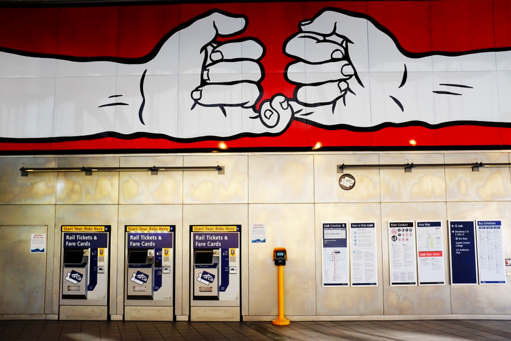 Mural of two interlinked hands on the wall at the Capitol Hill Light Rail Station