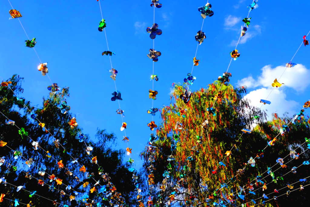 Shiny garlands stretch across a view of the sky and trees from below