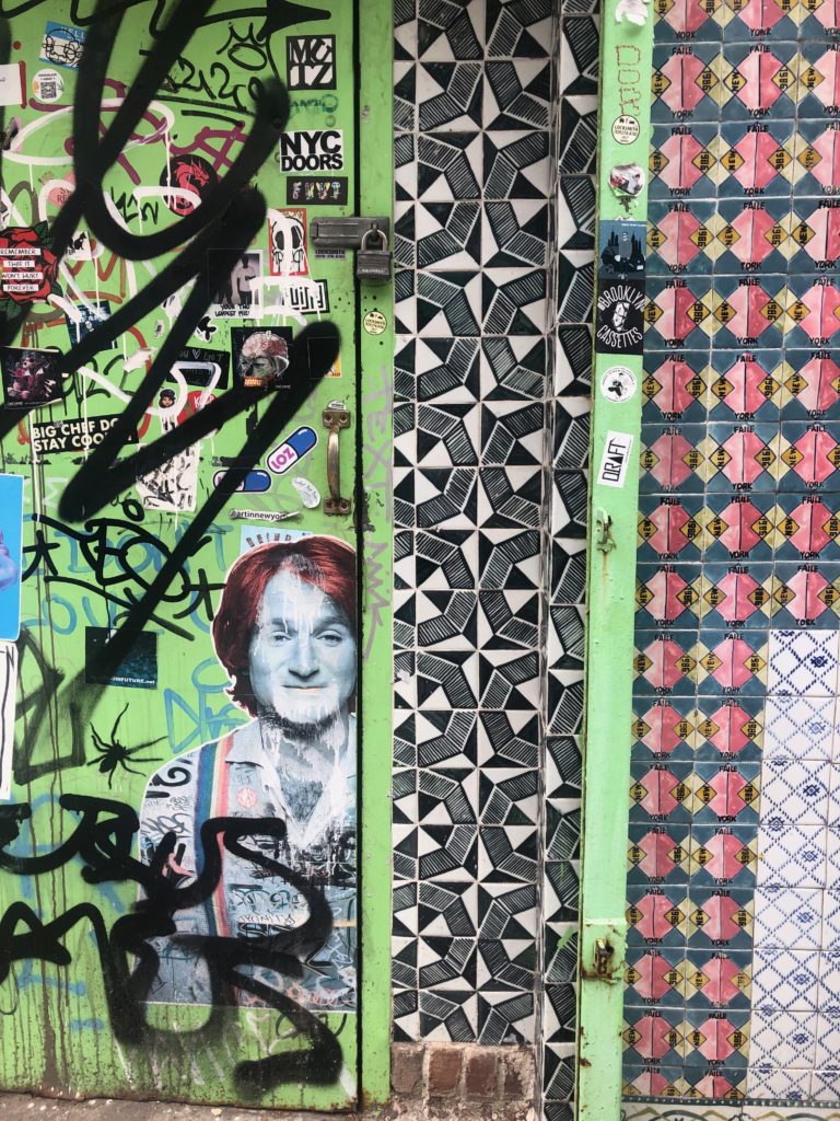 a stencil of Robin Williams and patterned tile on a wall