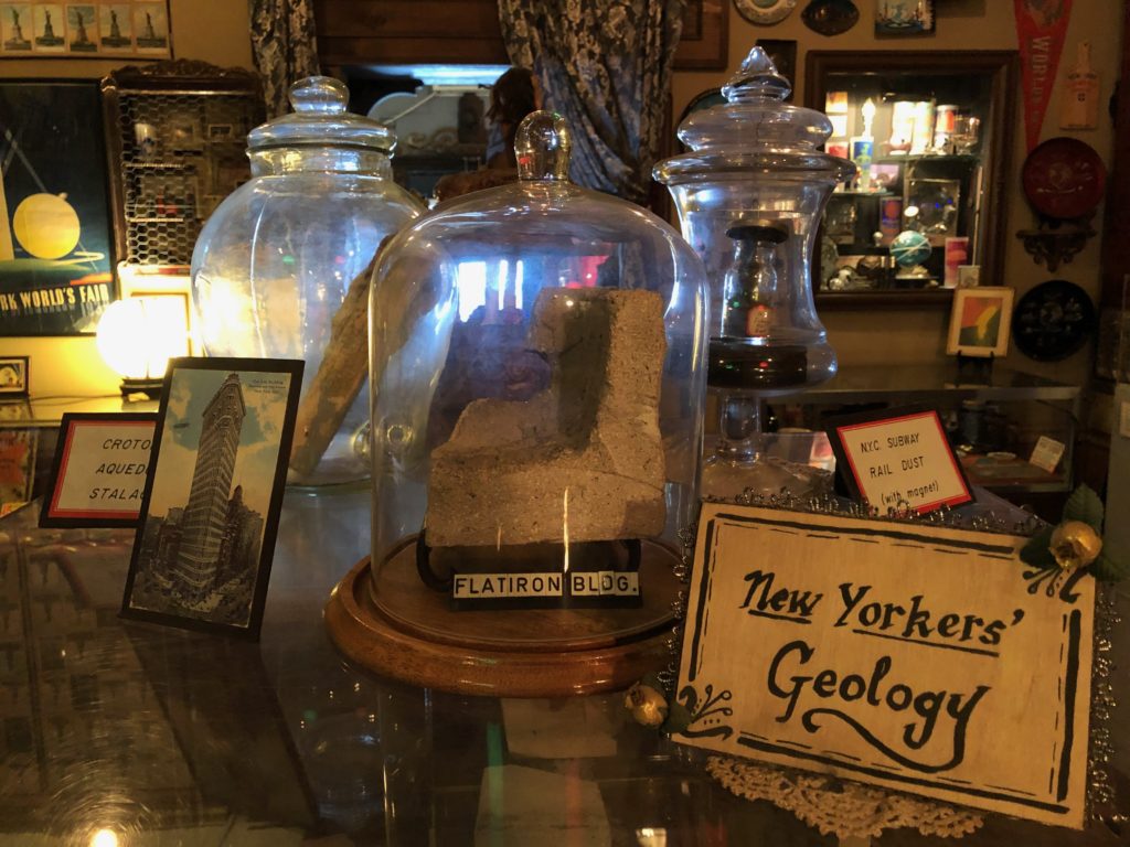 glass domes cover rock samples; the one in the foreground has a card that reads "Flatiron Bldg."