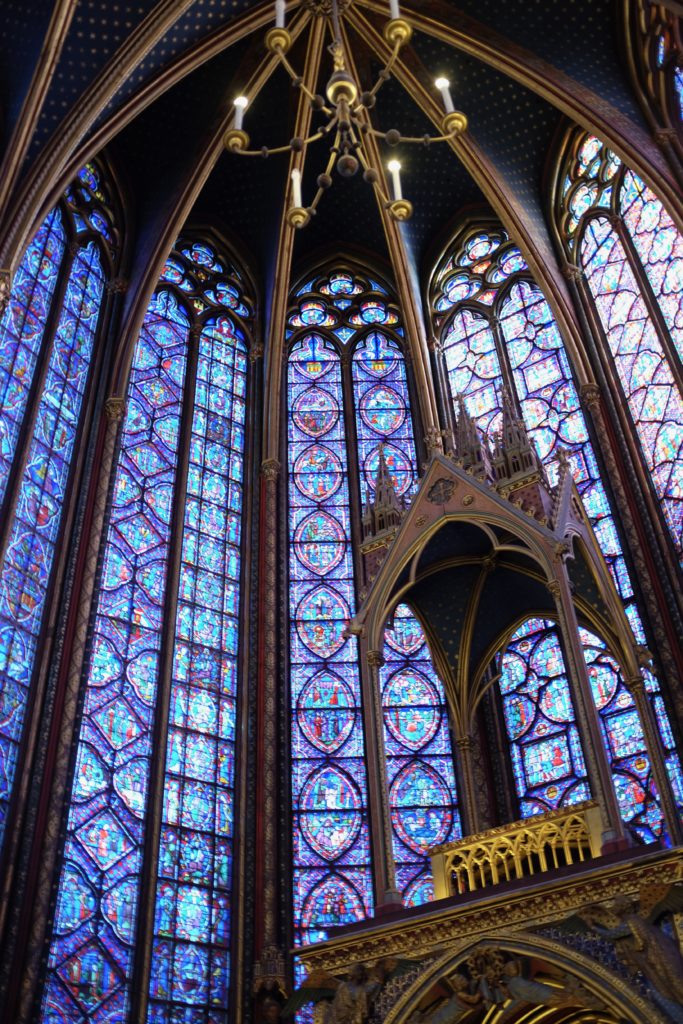 Tall stained glass windows at Sainte-Chapelle in Paris, with part of the altar in the foreground